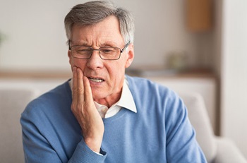man holding mouth aching 